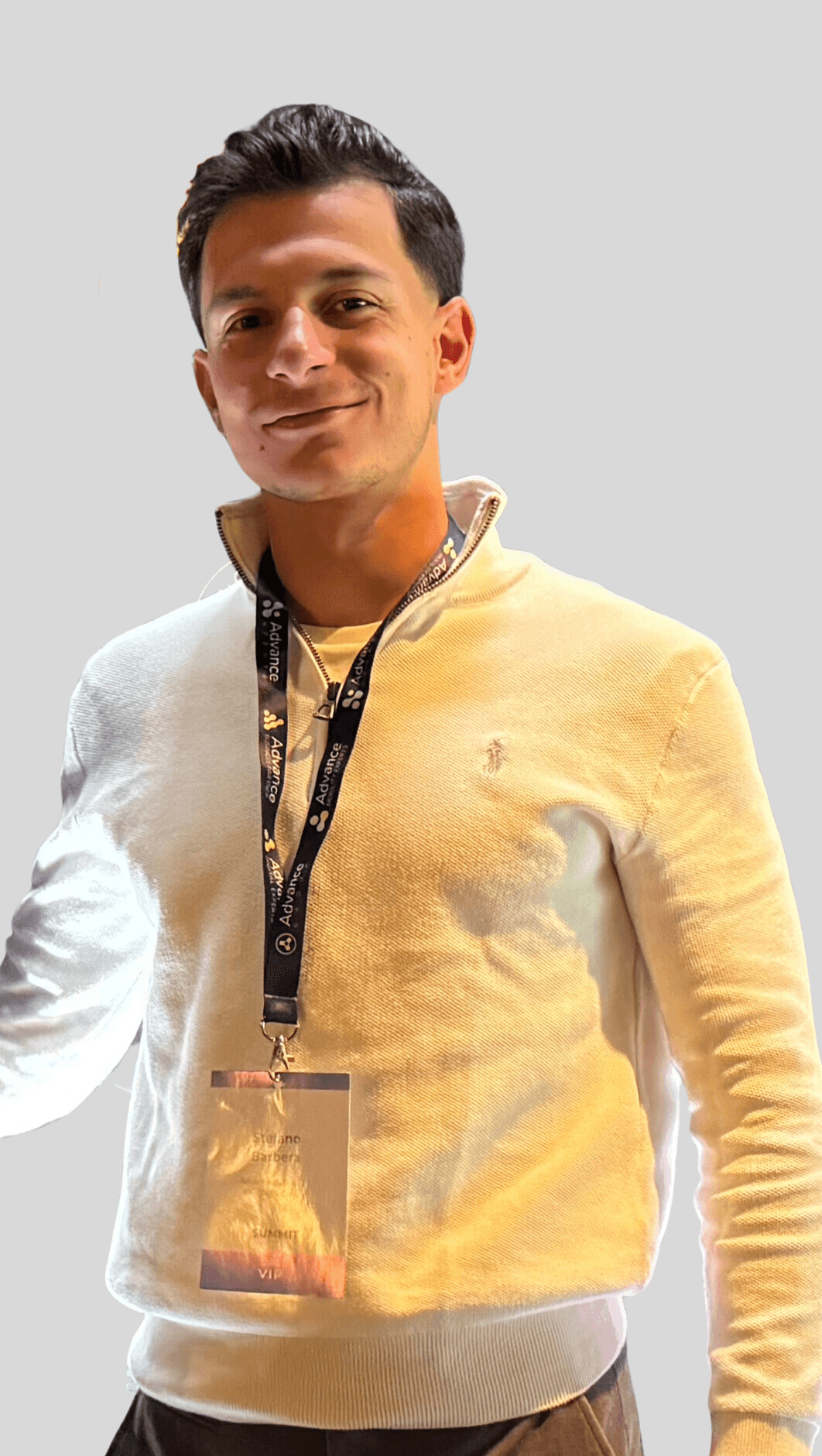 Person wearing a white sweater and a conference lanyard with a VIP badge.